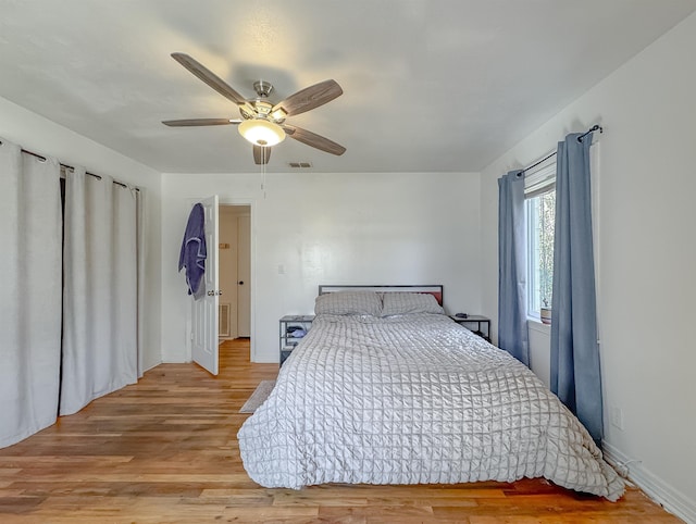 bedroom featuring light wood-type flooring, visible vents, ceiling fan, and baseboards