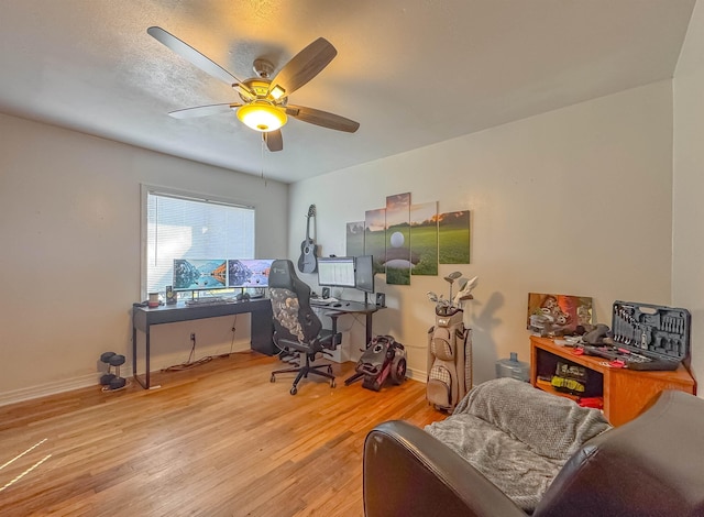 office featuring a ceiling fan, light wood-type flooring, and baseboards