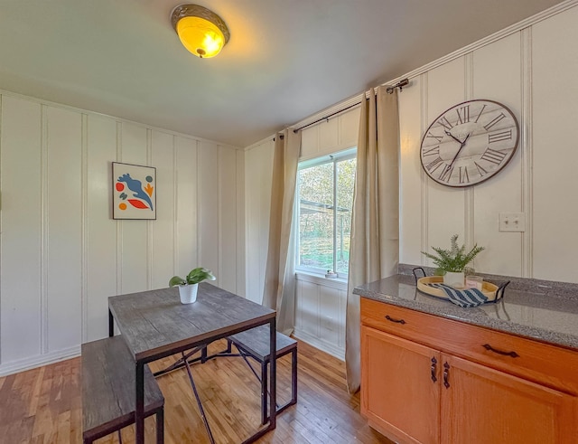 dining room with light wood-style flooring and a decorative wall