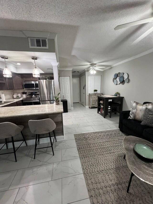 living room featuring ornamental molding, a textured ceiling, ceiling fan, and sink