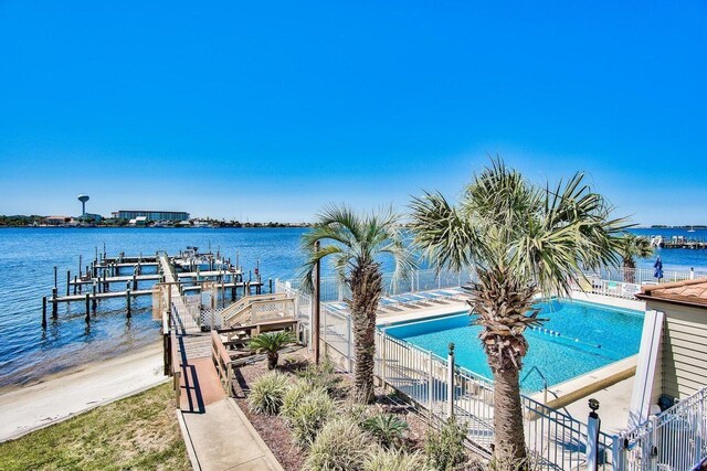 dock area featuring a community pool and a water view