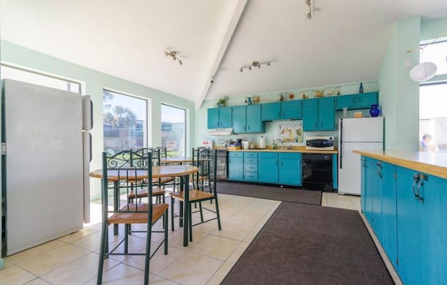 kitchen with blue cabinets, sink, light tile patterned flooring, lofted ceiling with beams, and white appliances