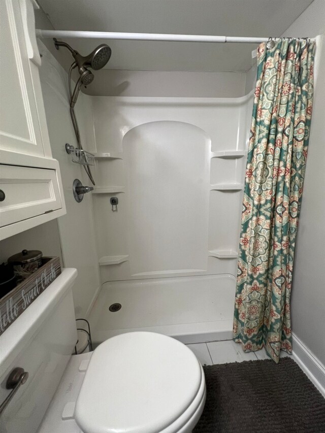 bathroom featuring toilet and a shower with curtain