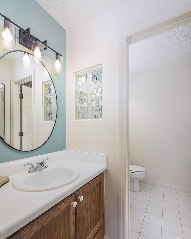 bathroom featuring tile patterned floors, vanity, toilet, and a textured ceiling