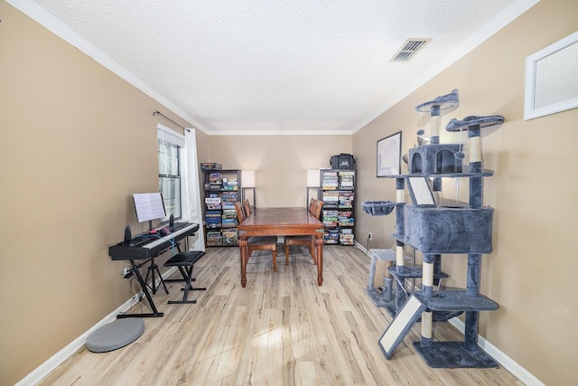 office space featuring crown molding, light hardwood / wood-style flooring, and a textured ceiling