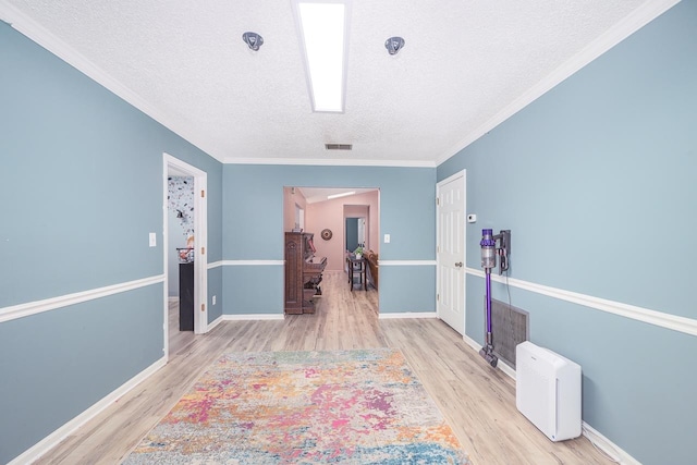 hallway featuring a textured ceiling, light hardwood / wood-style floors, and ornamental molding