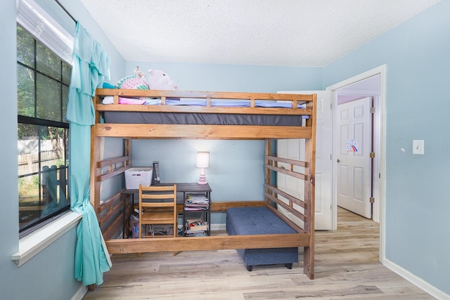 bedroom featuring a textured ceiling and light hardwood / wood-style flooring