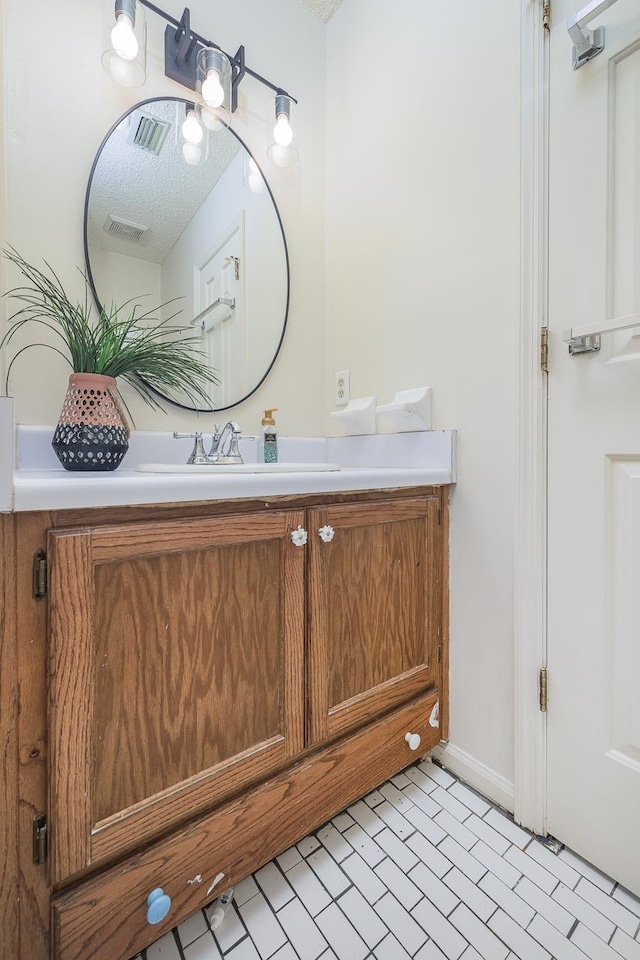 bathroom featuring tile patterned floors, vanity, and a textured ceiling