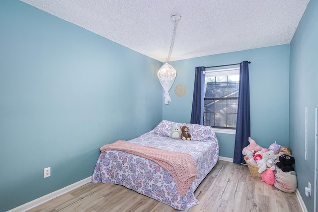 bedroom featuring a textured ceiling and light wood-type flooring