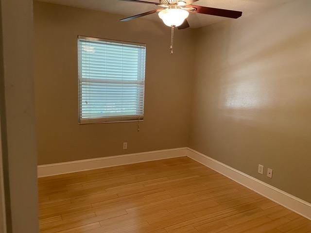 empty room with ceiling fan and light hardwood / wood-style flooring