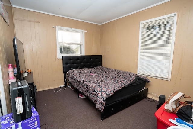 bedroom with carpet flooring, ornamental molding, and wooden walls