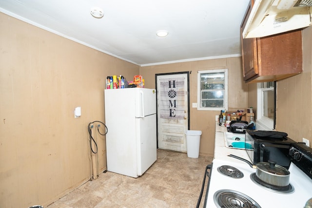 kitchen with crown molding, wooden walls, extractor fan, and white appliances