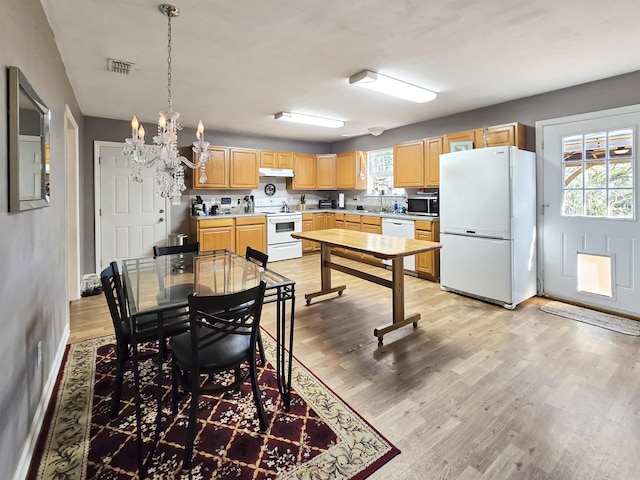 dining area featuring an inviting chandelier and light hardwood / wood-style floors