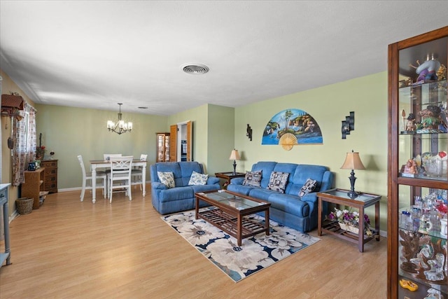 living area with a notable chandelier, baseboards, visible vents, and light wood-style floors