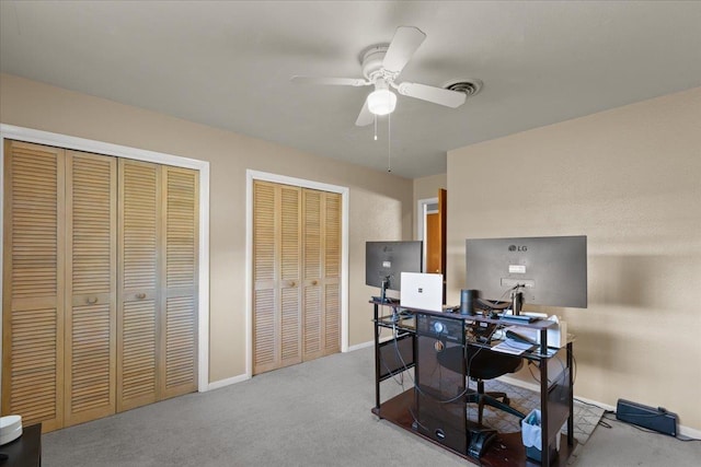 office space with carpet floors, ceiling fan, visible vents, and baseboards