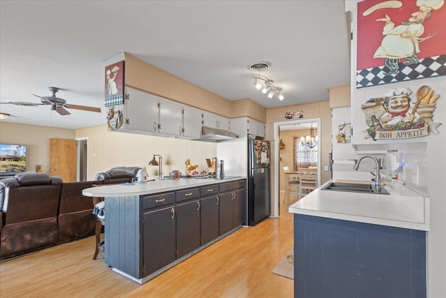 kitchen with light countertops, open floor plan, visible vents, and a sink