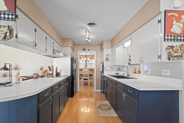 kitchen featuring light wood-style flooring, a sink, visible vents, light countertops, and an inviting chandelier