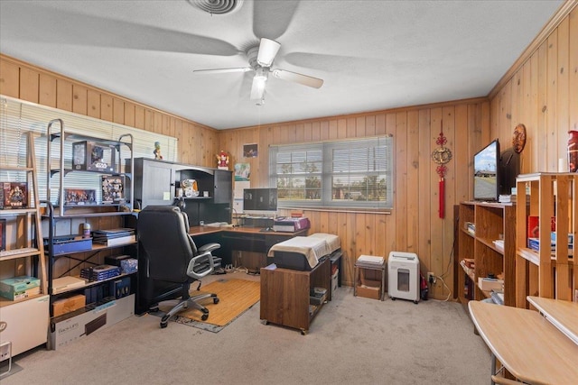 carpeted office with ceiling fan and wooden walls