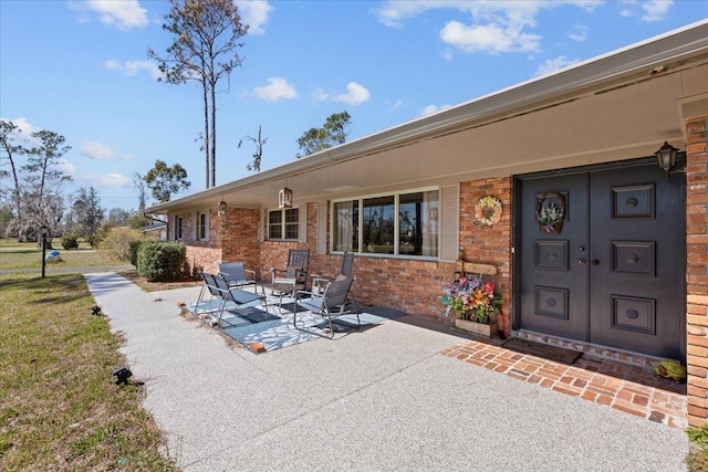 exterior space featuring a patio area and brick siding