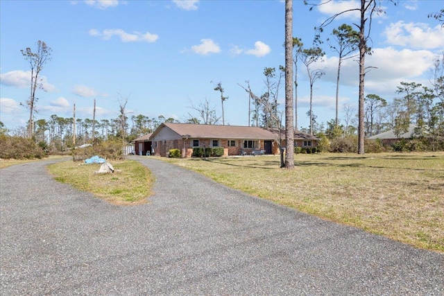 view of front of property with driveway, an attached garage, and a front lawn