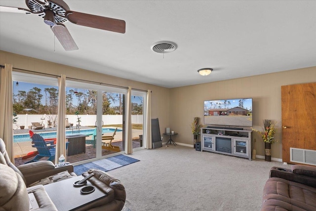 carpeted living area featuring ceiling fan, visible vents, and baseboards