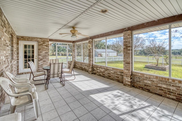 unfurnished sunroom with ceiling fan