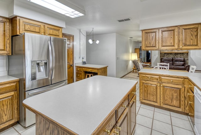 kitchen with stainless steel refrigerator with ice dispenser, an inviting chandelier, light tile patterned floors, and a center island