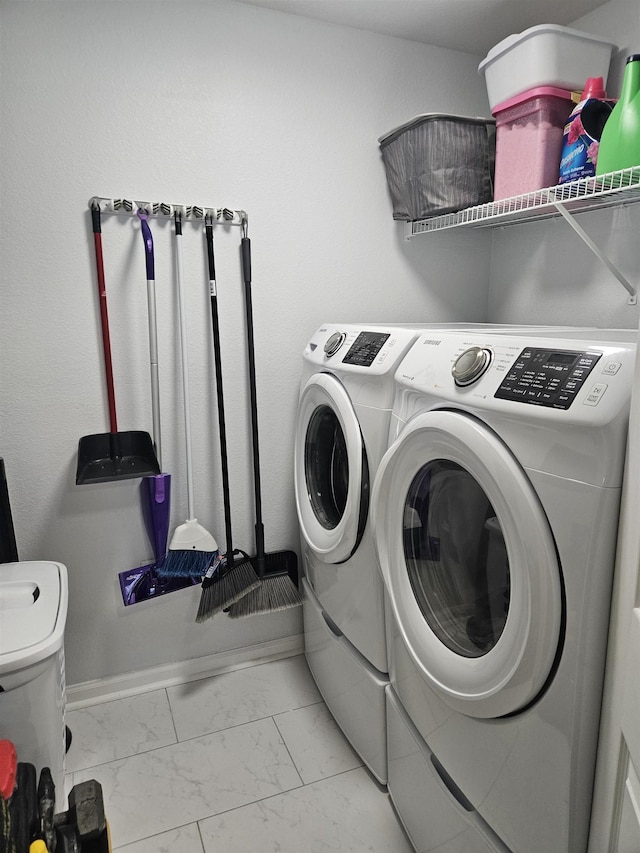 clothes washing area featuring laundry area, baseboards, marble finish floor, and independent washer and dryer