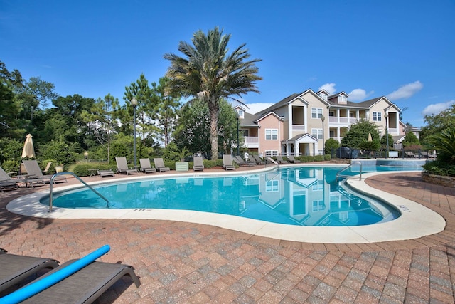 pool with a residential view and a patio