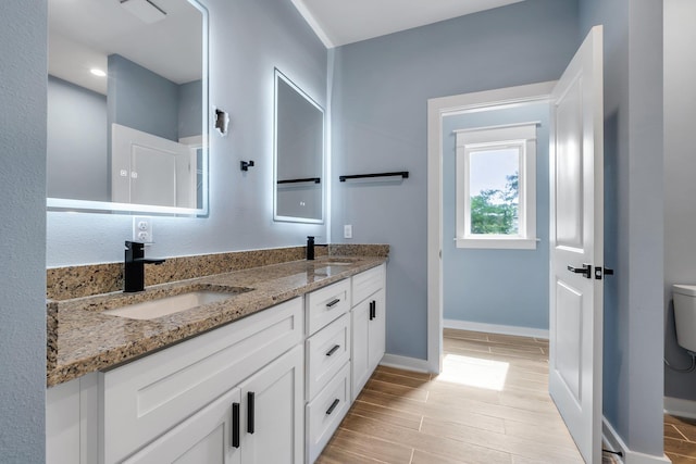 279 Ayers Ct, Tallahassee, FL 32305 - full bathroom with toilet, double vanity, baseboards, and wood finished floors