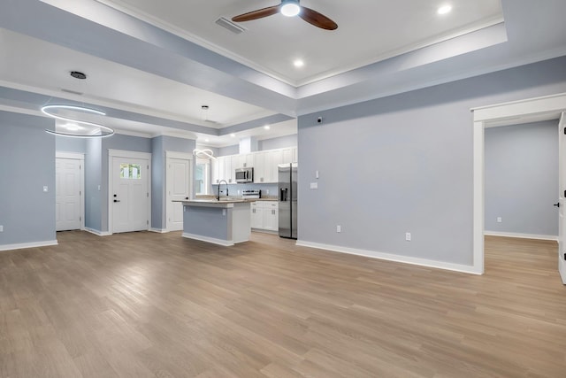 279 Ayers Ct, Tallahassee, FL 32305 - unfurnished living room featuring a ceiling fan, a tray ceiling, light wood-style floors, crown molding, and baseboards