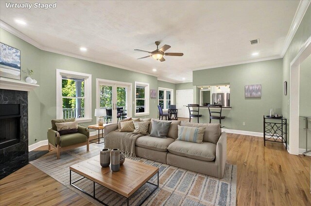 9078 Shoal Creek Dr, Tallahassee, FL 32312 - living area with ceiling fan, wood finished floors, a premium fireplace, crown molding, and baseboards