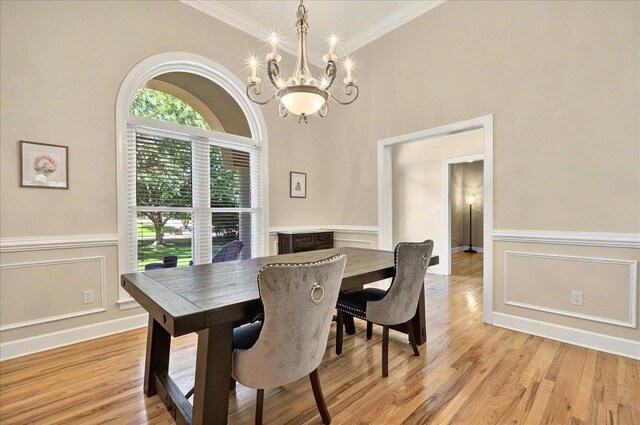 9078 Shoal Creek Dr, Tallahassee, FL 32312 - dining space with a chandelier, ornamental molding, light wood-type flooring, a wainscoted wall, and a decorative wall