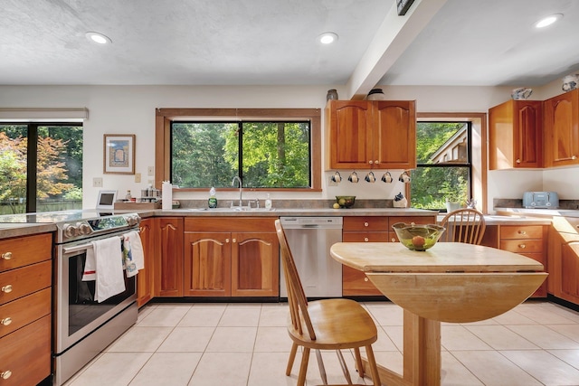 988 Timber Run, Havana, FL 32333 - kitchen featuring stainless steel appliances, a sink, brown cabinets, recessed lighting, and light tile patterned floors
