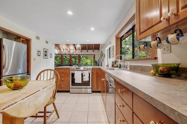 988 Timber Run, Havana, FL 32333 - kitchen with appliances with stainless steel finishes, a sink, brown cabinetry, light tile patterned flooring, and recessed lighting
