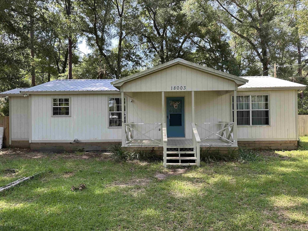 18003 Rakestraw Dr, Tallahassee, FL 32310 - view of front facade featuring a metal roof, a front yard, and a porch