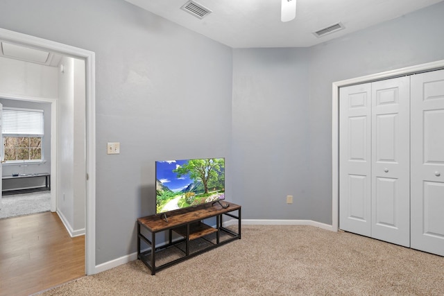 living area featuring carpet floors and ceiling fan