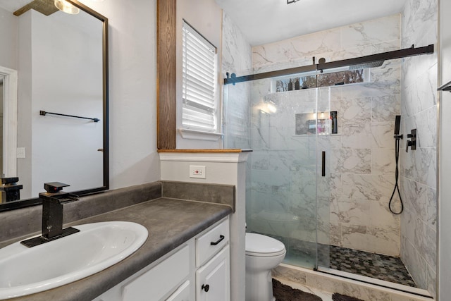 bathroom with an enclosed shower, vanity, and toilet