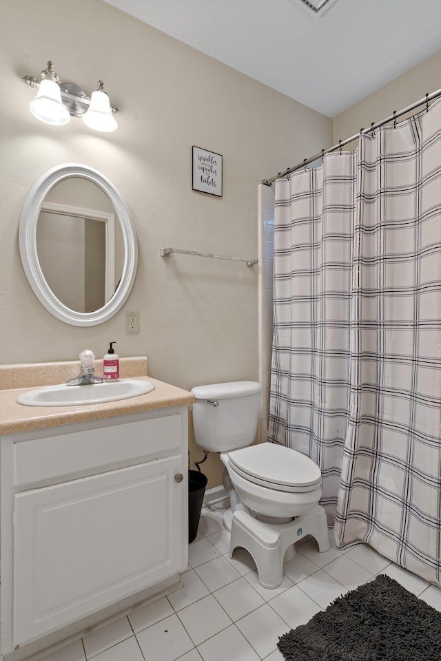 bathroom with tile patterned flooring, vanity, and toilet