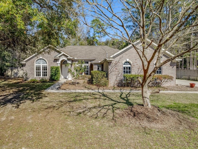 ranch-style house featuring brick siding and a front yard
