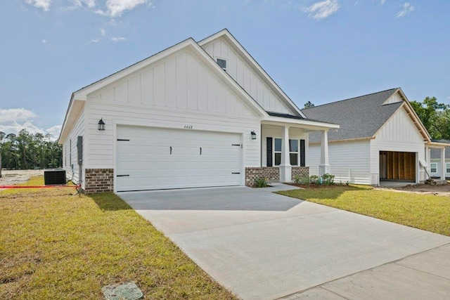 4468 River Breeze Ln, Tallahassee, FL 32303 - view of front facade with board and batten siding, central air condition unit, a front lawn, an attached garage, and concrete driveway