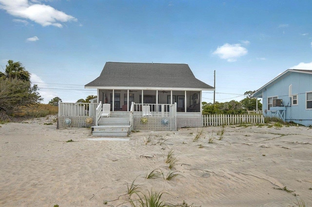1195 Alligator Dr, Alligator Point, FL 32346 - rear view of property featuring a sunroom, roof with shingles, and fence
