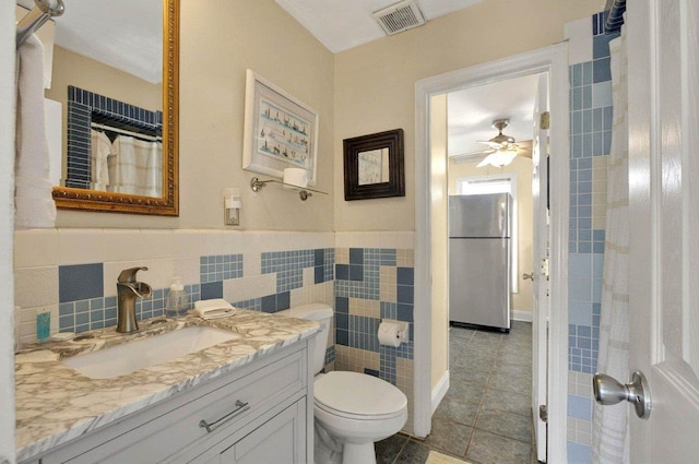 1195 Alligator Dr, Alligator Point, FL 32346 - bathroom featuring a ceiling fan, tile walls, toilet, tile patterned floors, and vanity