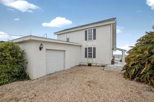 1195 Alligator Dr, Alligator Point, FL 32346 - back of house with stucco siding and an attached garage