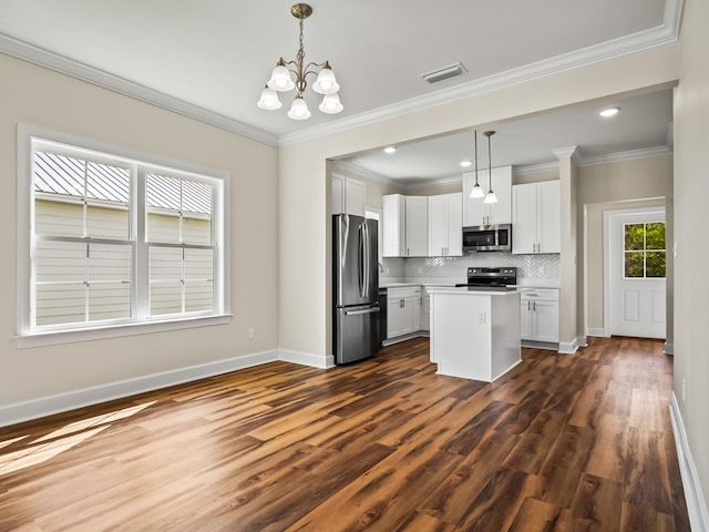 kitchen with white cabinets, dark hardwood / wood-style floors, decorative light fixtures, and appliances with stainless steel finishes