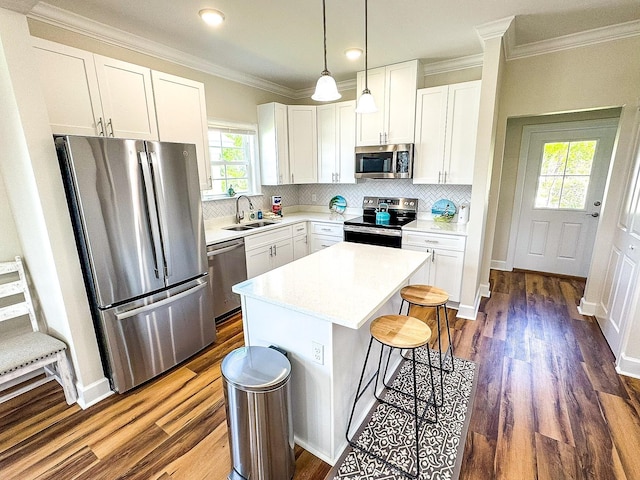 254 Ante Beppum Loop, Carrabelle, FL 32322 - kitchen with appliances with stainless steel finishes, a kitchen island, dark wood-style flooring, a kitchen bar, and light countertops