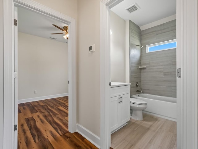 full bathroom with wood-type flooring, toilet, tiled shower / bath, vanity, and ceiling fan