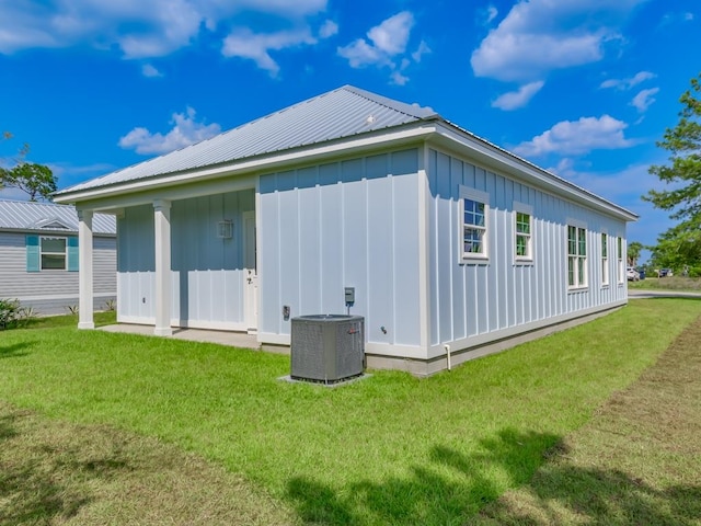 view of property exterior with central AC unit and a yard