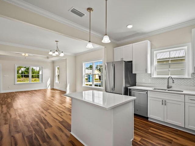 kitchen with white cabinets, stainless steel appliances, a healthy amount of sunlight, and dark hardwood / wood-style floors