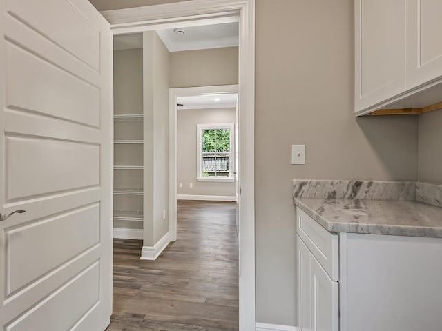 bar with crown molding, white cabinets, and wood-type flooring